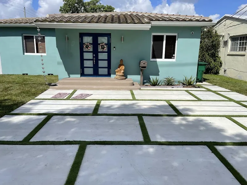 Turf strips installed in the joints between concrete driveway pads