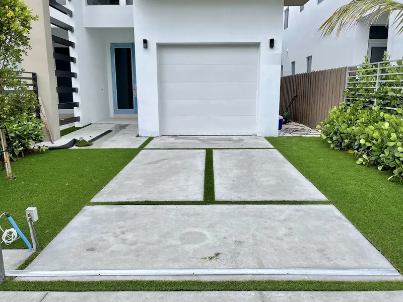 Modern front yard with turf framing concrete driveway pads