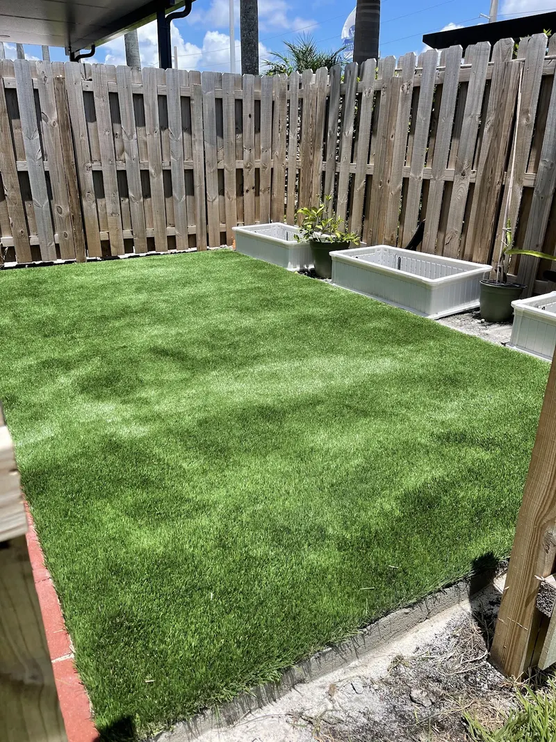 Fenced backyard finished in turf with raised planter boxes