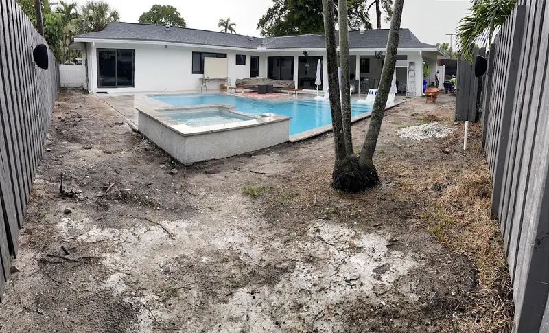 Backyard before the install: bare dirt around a new pool