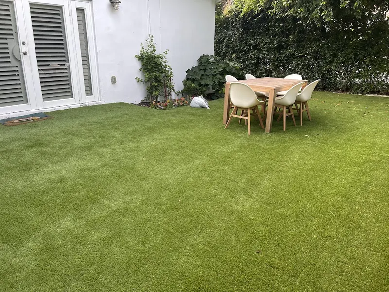 Backyard turf lawn with a patio dining set