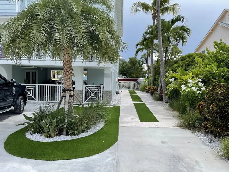 Curved turf bed and turf stepping strips along a front walkway
