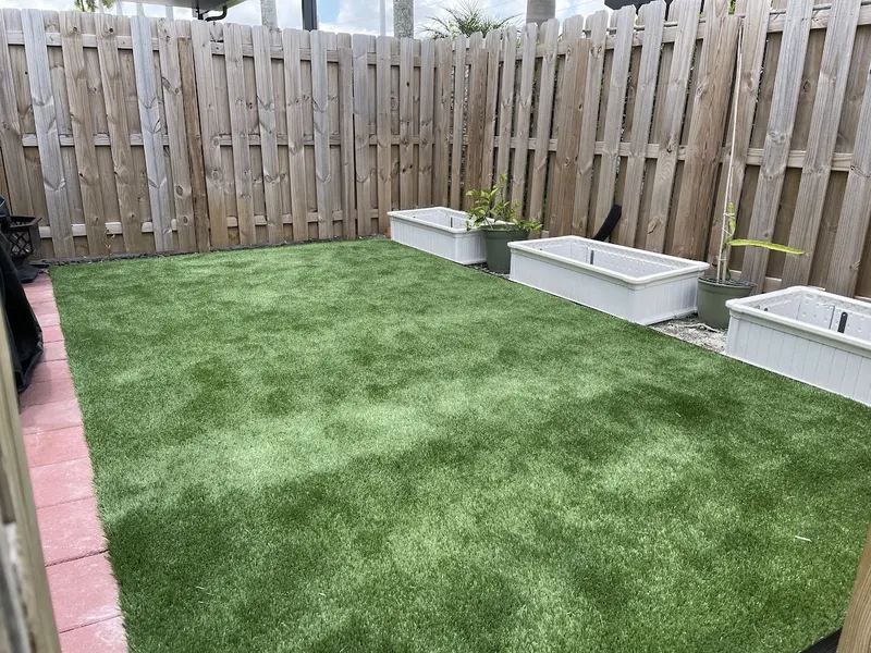 Fenced backyard of turf with planter boxes