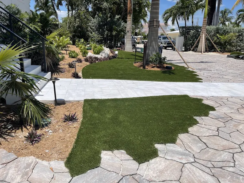 Turf set into natural flagstone pavers beside a garden