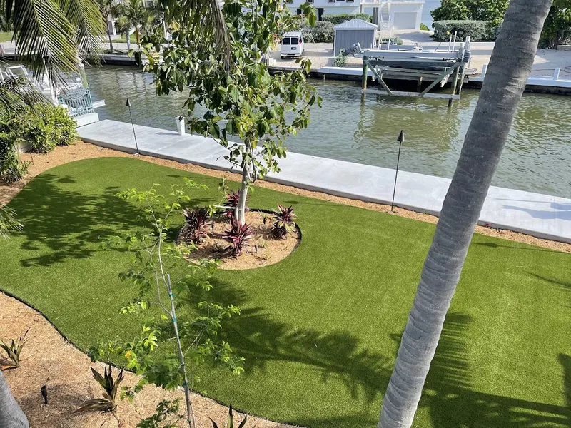 Turf lawn with a tree bed along a canal seawall, seen from above