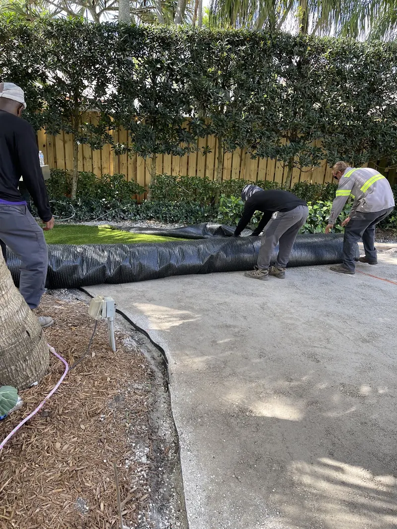 Crew rolling turf out over a prepared base