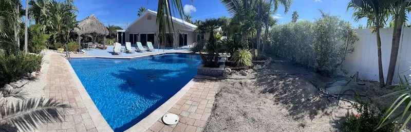 Backyard before the install: bare dirt beside a pool