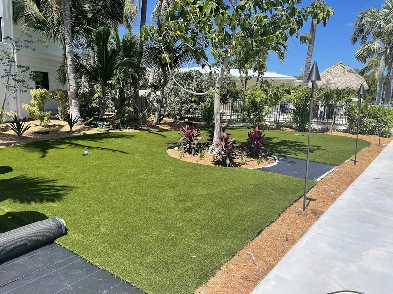 Turf lawn finished around planted beds in a backyard