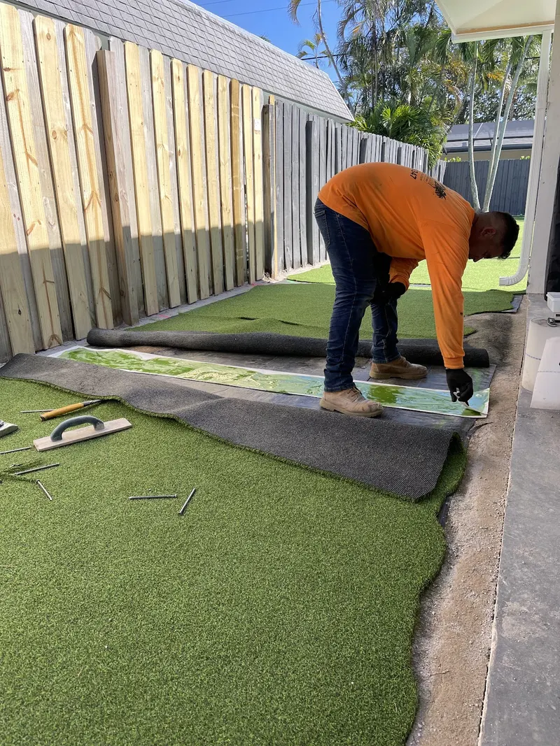 Installer finishing a seam along the fence line