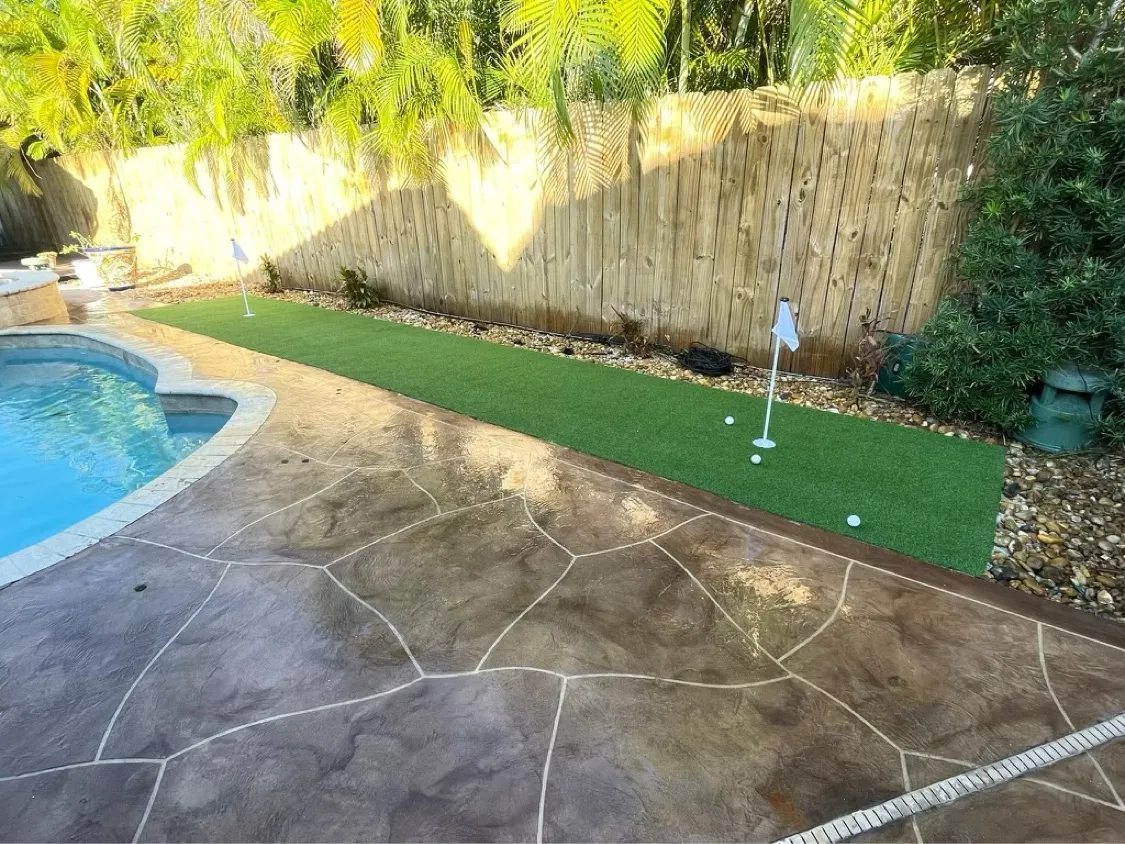 The repaired green running the length of the pool deck
